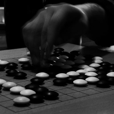 You lay the stones onto the Goban holding them between the index and middle fingertips